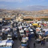 Des camions pleins d'effets de réfugiés syriens attendent de franchir la frontière pour entrer en Syrie depuis la ville libanaise d'Arsal.